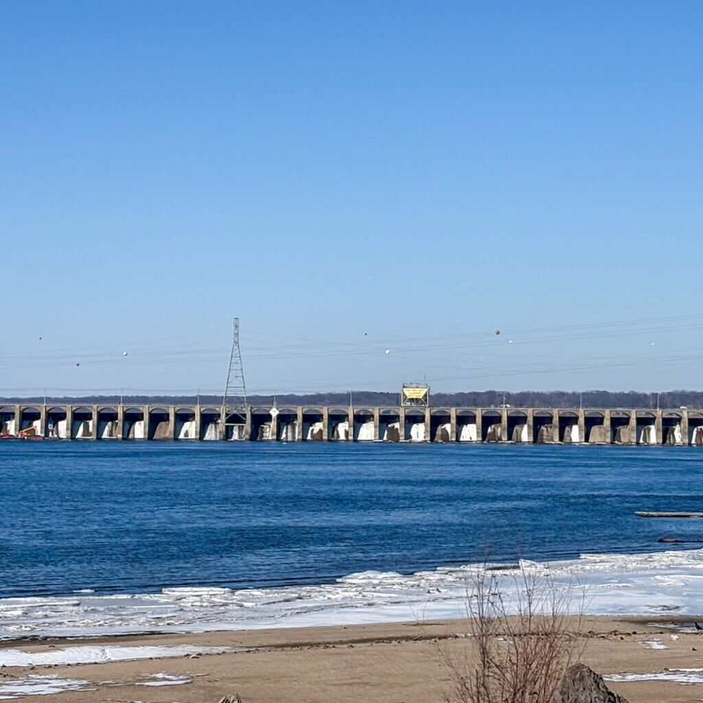 Distance view of the Keokuk Spillway in Keokuk, Iowa. The restoration tackles a deceptively complex challenge, refacing dozens of curved spillway surfaces while securely anchoring formwork to the existing aging dam structure.